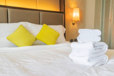 Otel odasında beyaz havlu katlanır.
