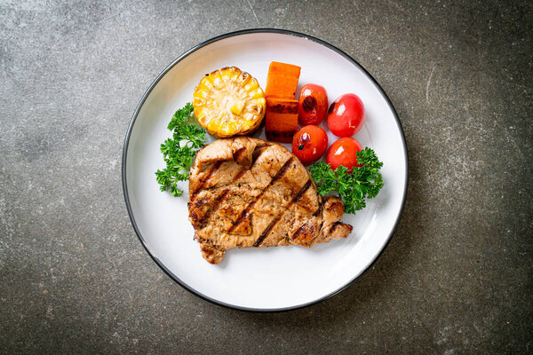 grilled and barbecue fillet pork steak with corn, carrot and tomatoes