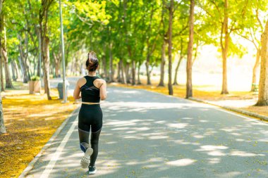 Parkta koşan Asyalı kadın.