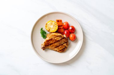 Izgara ve ızgara fileto domuz bifteği, mısır, havuç ve domates.