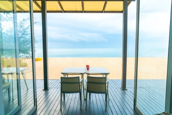 empty dining table in restaurant with sea beach background