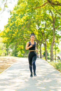 Parkta koşan Asyalı kadın.