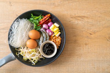 Tavada malzemeli pirinç eriştesi Pad Thai pişirmeye hazır.