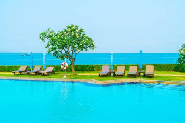 Havuz kenarındaki havuz, havuz, şemsiye, deniz manzaralı havuz tatilleri ve tatil konsepti.