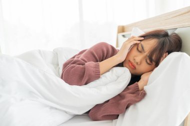 Güzel Asyalı kadınların baş ağrısı ve yatakta uyuması.