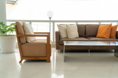 Boş kanepe ve yastıklı sandalye bir odada.