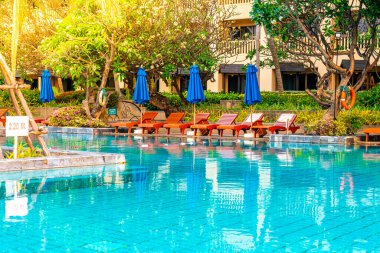 Otelde ve tatil beldesinde yüzme havuzunda güzel şemsiye ve sandalye - tatil ve tatil konseri