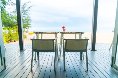 Deniz sahili geçmişi olan restoranda boş bir yemek masası.