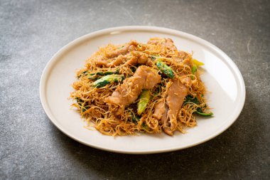 Kızarmış pirinç vermicelli şehriyeli, siyah soya soslu ve domuz etli, Asya usulü.