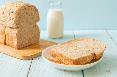 Tahta bir masada dilimlenmiş kepekli ekmek.