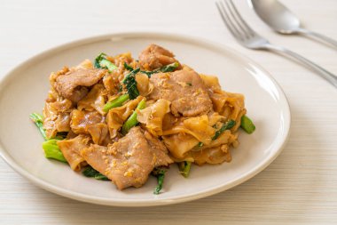 Kızarmış pirinç eriştesi, soya sosu, domuz eti ve lahana. Asya usulü.