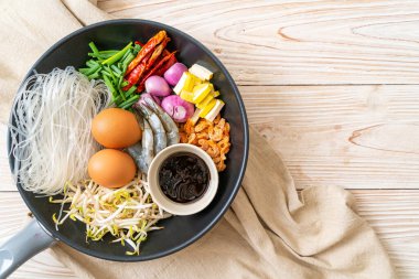 Tavada malzemeli pirinç eriştesi Pad Thai pişirmeye hazır.