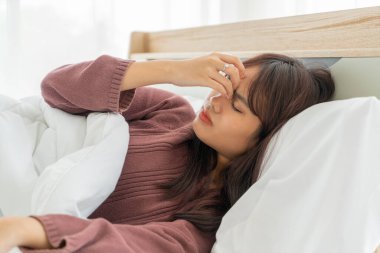 Güzel Asyalı kadınların baş ağrısı ve yatakta uyuması.