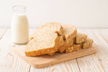 Tahta bir masada dilimlenmiş kepekli ekmek.