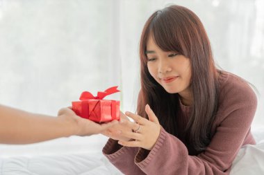Asyalı kadınlar hediye kutusu veya hediye almaktan mutlu olurlar.