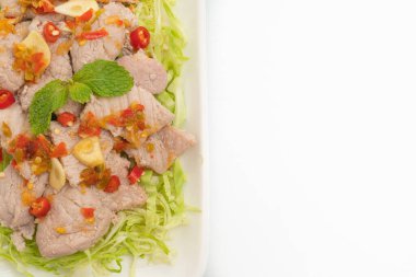 Baharatlı domuz salatası ya da limon sarımsaklı haşlanmış domuz eti ve beyaz arka planda izole edilmiş acılı sos.