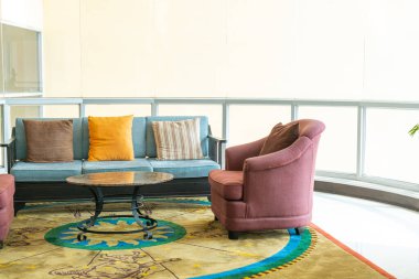 Boş kanepe ve yastıklı sandalye bir odada.