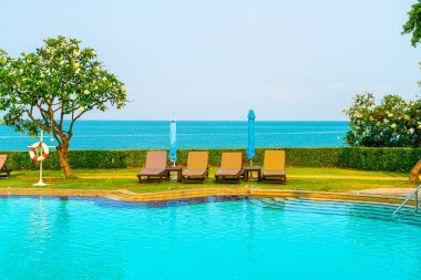 Havuz kenarındaki havuz, havuz, şemsiye, deniz manzaralı havuz tatilleri ve tatil konsepti.