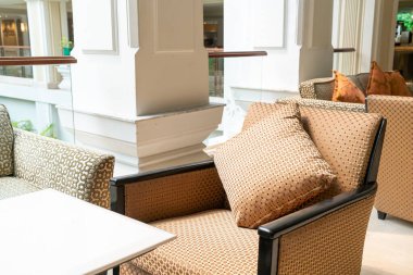 Boş kanepe ve yastıklı sandalye bir odada.