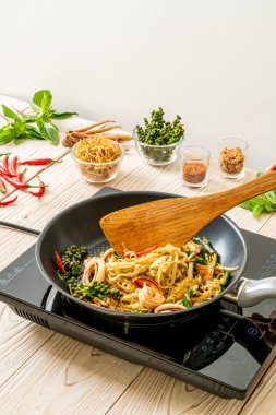 Kızarmış erişteyi sebzeyle karıştır ve tavada et