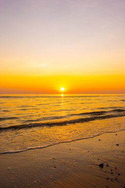 Alacakaranlık gökyüzü ve deniz plajı ile güzel bir gün doğumu ya da gün batımı
