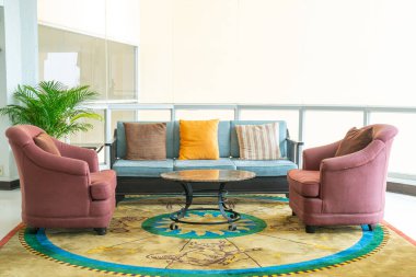 Boş kanepe ve yastıklı sandalye bir odada.