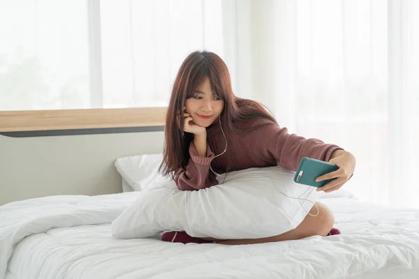 美しいアジアの女性たちがベッドでスマホを — ストック写真