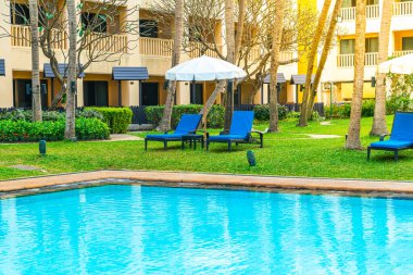 Otel havuzunda yüzme havuzu ve şemsiyesi