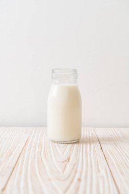 Ahşap arka planda şişede taze süt