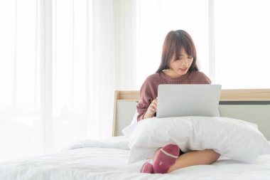 Evde dizüstü bilgisayarla çalışan Asyalı kadınlar.