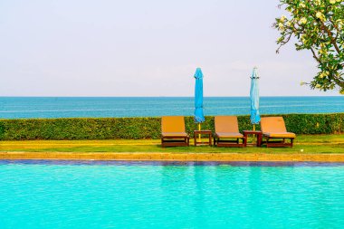 Havuz kenarındaki havuz, havuz, şemsiye, deniz manzaralı havuz tatilleri ve tatil konsepti.