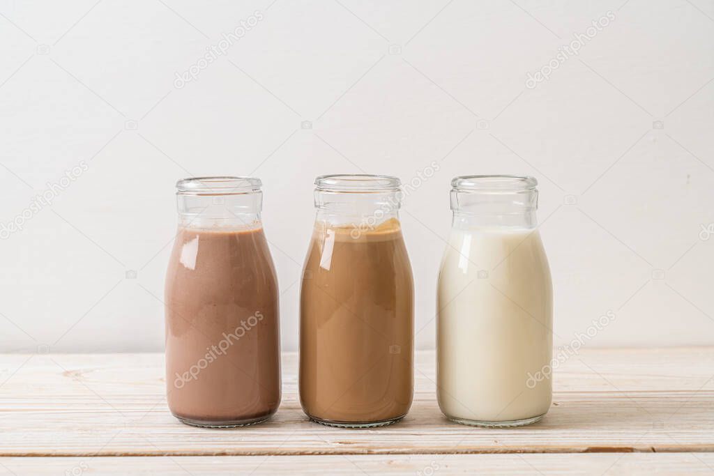 Collection of beverage chocolate milk, coffee and fresh milk in bottle on wood background