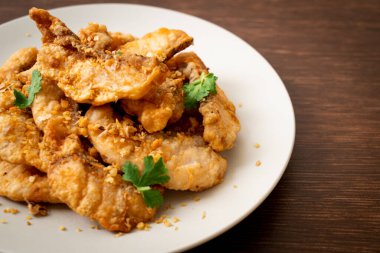 Tabakta sarımsaklı kızarmış balık.