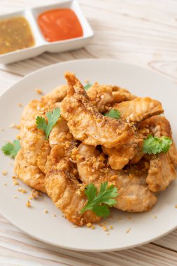 Tabakta sarımsaklı kızarmış balık.