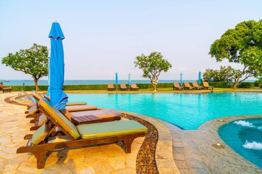 Havuz kenarındaki havuz, havuz, şemsiye, deniz manzaralı havuz tatilleri ve tatil konsepti.