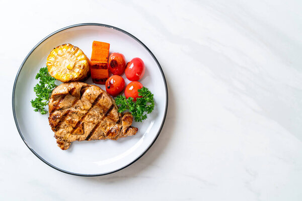 grilled and barbecue fillet pork steak with corn, carrot and tomatoes