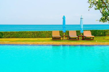 Havuz kenarındaki havuz, havuz, şemsiye, deniz manzaralı havuz tatilleri ve tatil konsepti.