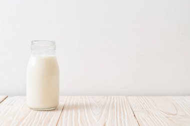 Ahşap arka planda şişede taze süt