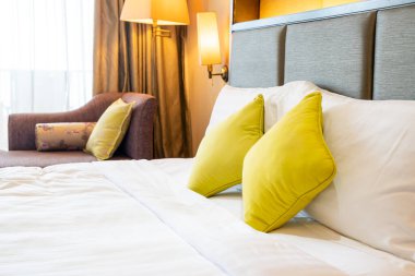 Otel odasındaki yatakta rahat yastık süslemesi