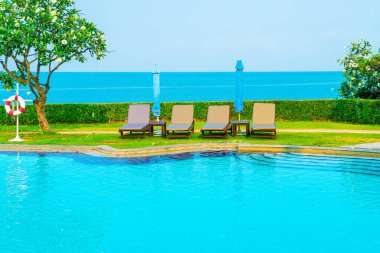 Havuz kenarındaki havuz, havuz, şemsiye, deniz manzaralı havuz tatilleri ve tatil konsepti.