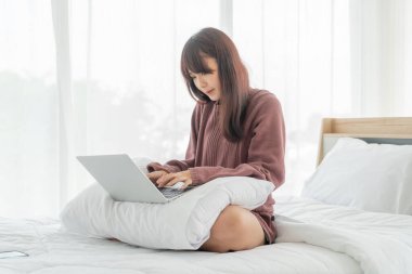 Evde dizüstü bilgisayarla çalışan Asyalı kadınlar.