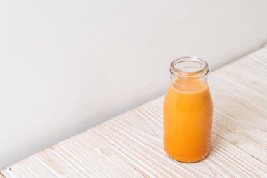 Tahta arka planda, şişede Tayland sütü çayı.