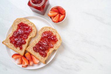 Çilek reçelli ve taze çilekli ev yapımı tam buğday ekmeği.