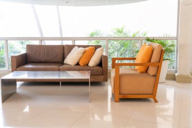 Boş kanepe ve yastıklı sandalye bir odada.