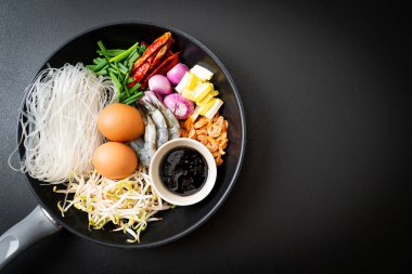 Tavada malzemeli pirinç eriştesi Pad Thai pişirmeye hazır.