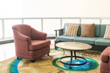 Boş kanepe ve yastıklı sandalye bir odada.