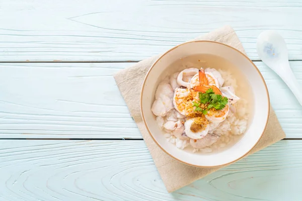 porridge or boiled rice soup with seafood (shrimps, squid and fish) bowl