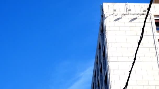 Tiro de rastreamento na fachada, com a bandeira do Fao acenando no céu azul — Vídeo de Stock