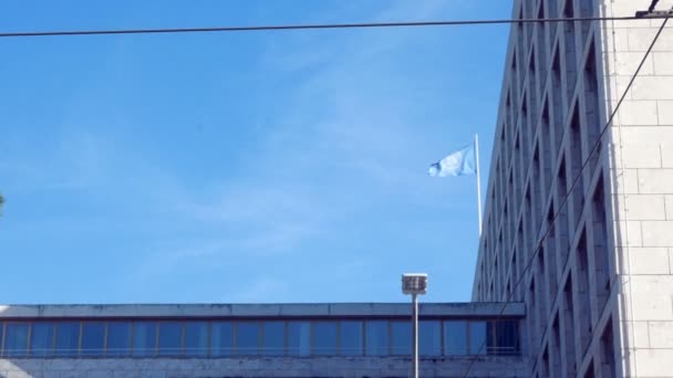 Tiro de seguimiento en la fachada, con la bandera del Fao ondeando en el cielo azul — Vídeo de stock