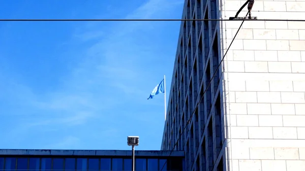 Tracciamento colpo sulla facciata, con la bandiera del Fao sventola nel cielo blu — Foto Stock